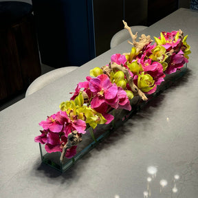 Moderne Haus-Glasvase mit pinkfarbenen Vanda-Orchideen und grünen Cymbidien