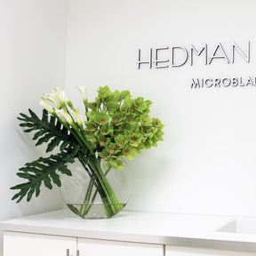 Lunar Vase mit grünen Cymbidien und Callas