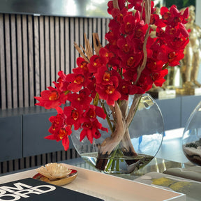 Rote Cymbidium-Orchideen im Moon-Pflanzgefäß